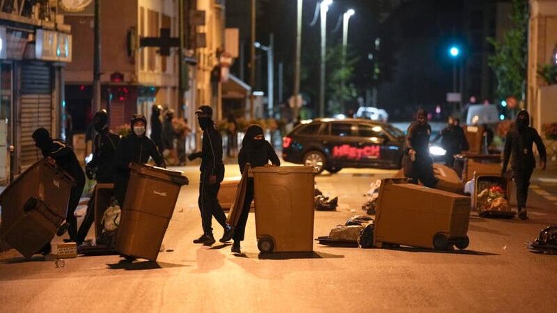 Protesters block a street with bins in Colombes, outside Paris (AP)