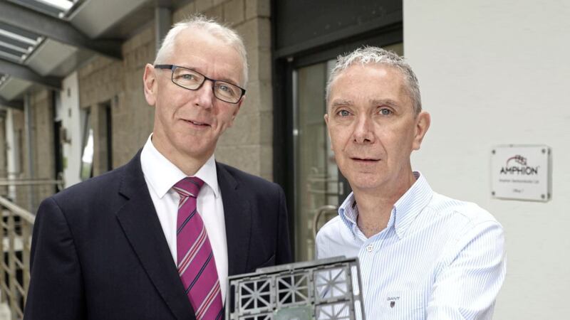 Belfast technology firm, Amphion Semiconductor is to create five new jobs in an investment that will help to support its export ambitions. Pictured holding the company&rsquo;s chip which contains its video codec IP are Brian Dolaghan, Invest NI, and Stephen Farson, Amphion 