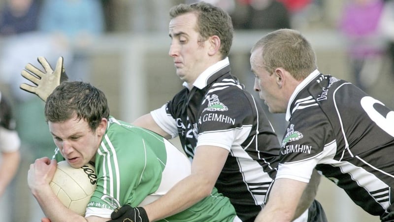 Loup&#39;s Declan McVey tries to escape the close attentions of Dungiven&#39;s Stephen McGuigan and Emmett McKeever at Celtic Park during the Derry SFC Final. 