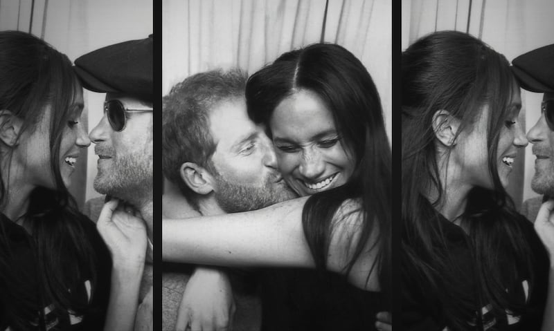 The couple cuddling in a photo booth 