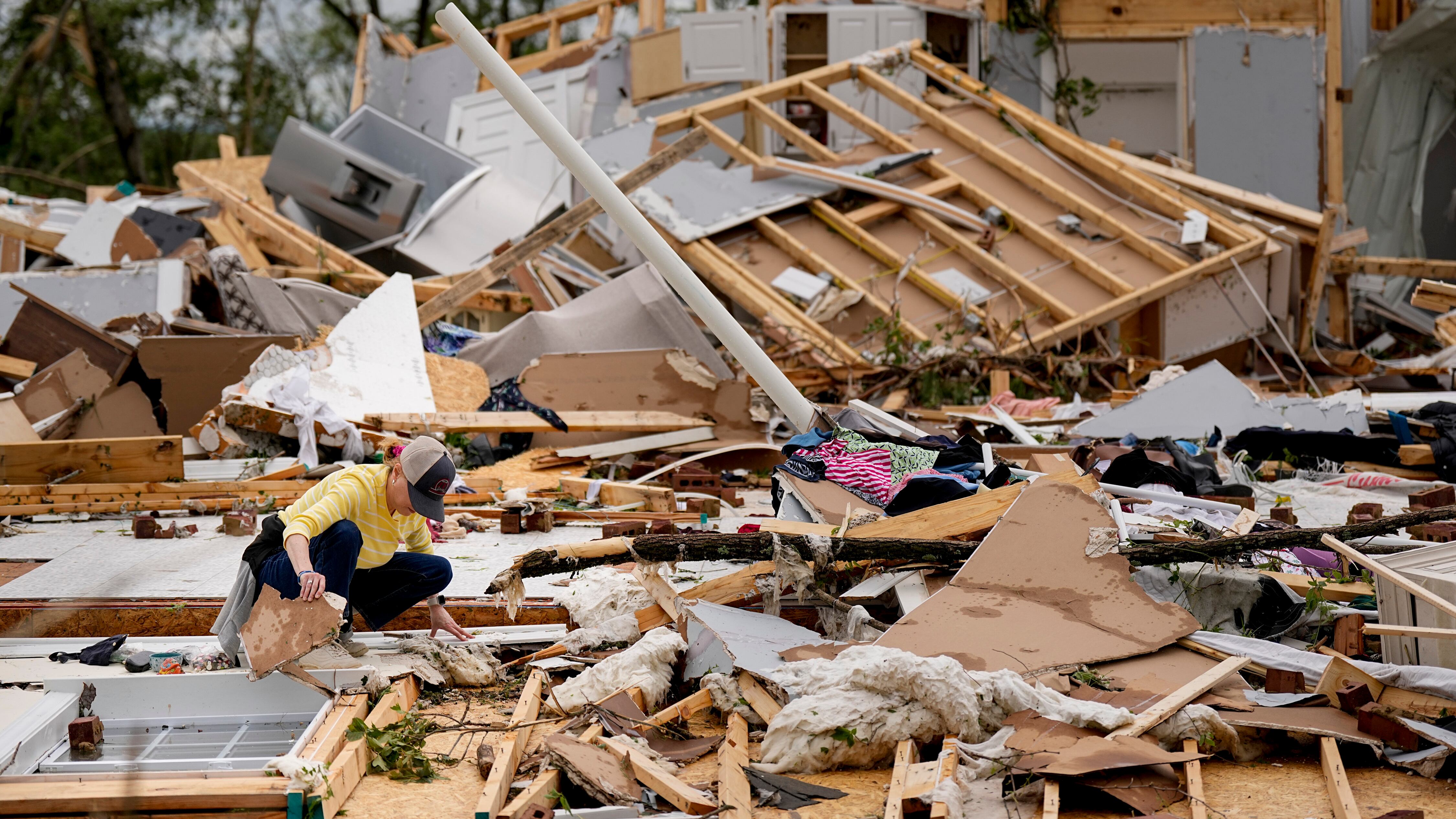 A woman looks through debris at her stormed damaged home in Columbia, Tennessee (George Walker/AP)