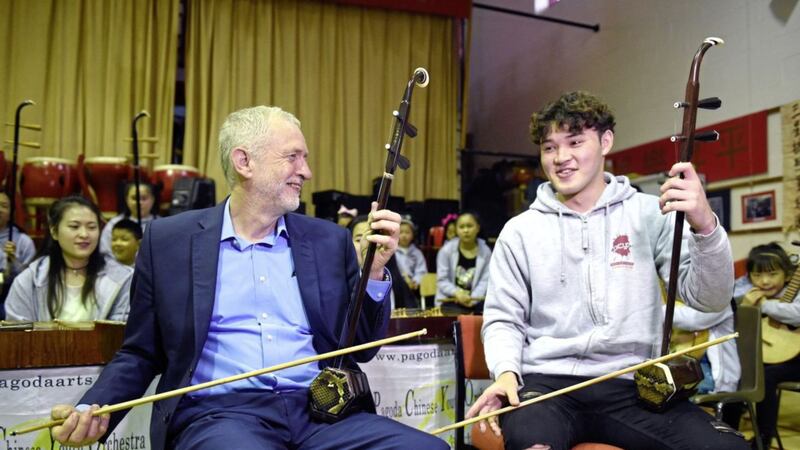 Labour leader Jeremy Corbyn with Charlie Wardle (17), playing an erhu during a community visit to Pagoda Arts in Liverpool on Sunday. Picture by Joe Giddens/PA 