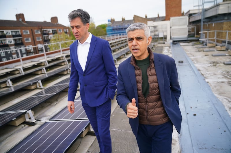Mayor of London Sadiq Khan and shadow energy secretary Ed Miliband, walk past solar panels installed on the roof of Stoke Newington School in north London
