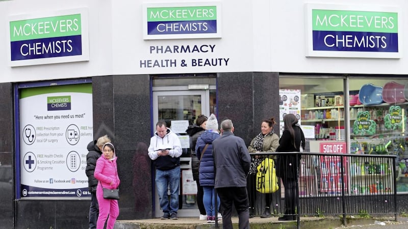 People queuing outside a pharmacy in west Belfast as they limited customer numbers to two at a time because of the coronavirus outbreak. Picture by Mal McCann 