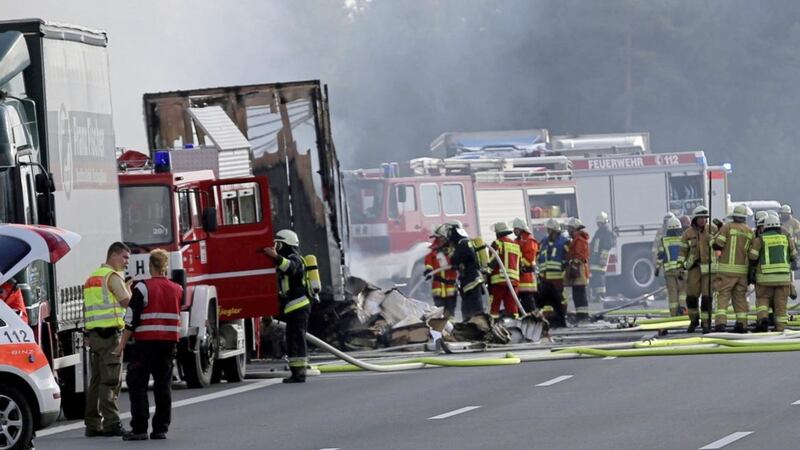 Rescue workers stand beside burnt-out coach on the motorway A9 near Muenchberg, southeastern Germany Picture: AP 
