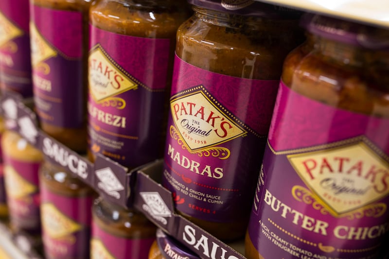 Jars of Patak's curry sauce on a shelf in a supermarket