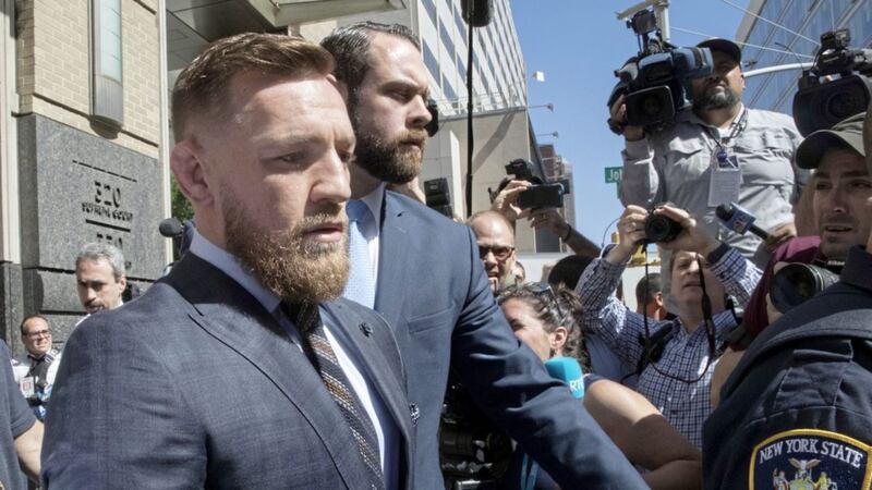 Conor McGregor is escorted byofficers as he leaves a Brooklyn Supreme court in June last year 