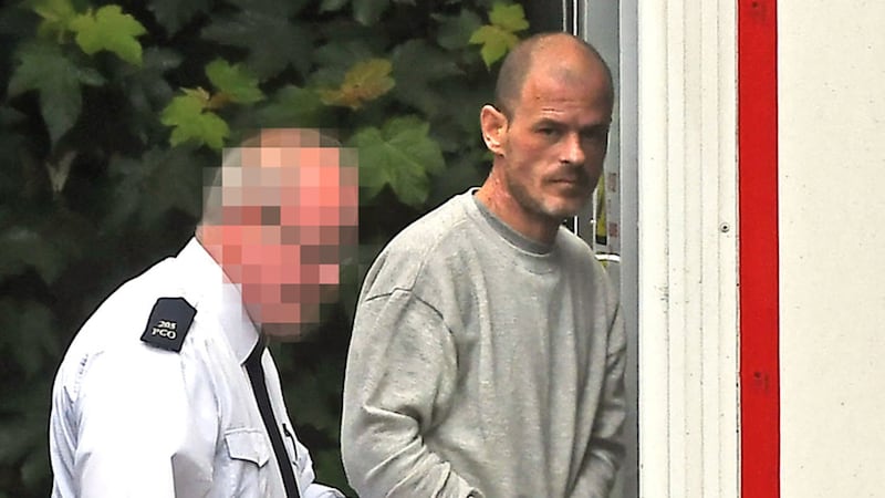 Thomas McEntee aged 40 is escorted by prison officers at Lisburn Court on Tuesday, charged with the murder of Michael and Majorie Cawdery in Portadown, County Armagh 