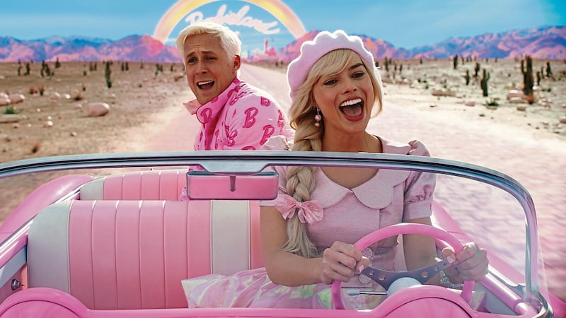 Ryan Gosling as Ken and Margot Robbie as Barbie ride in Barbie's car in a scene from the 2023 film directed by Greta Gerwig