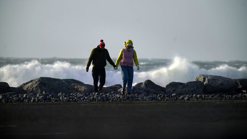 File phot of people walk along a seafront in County Clare .
