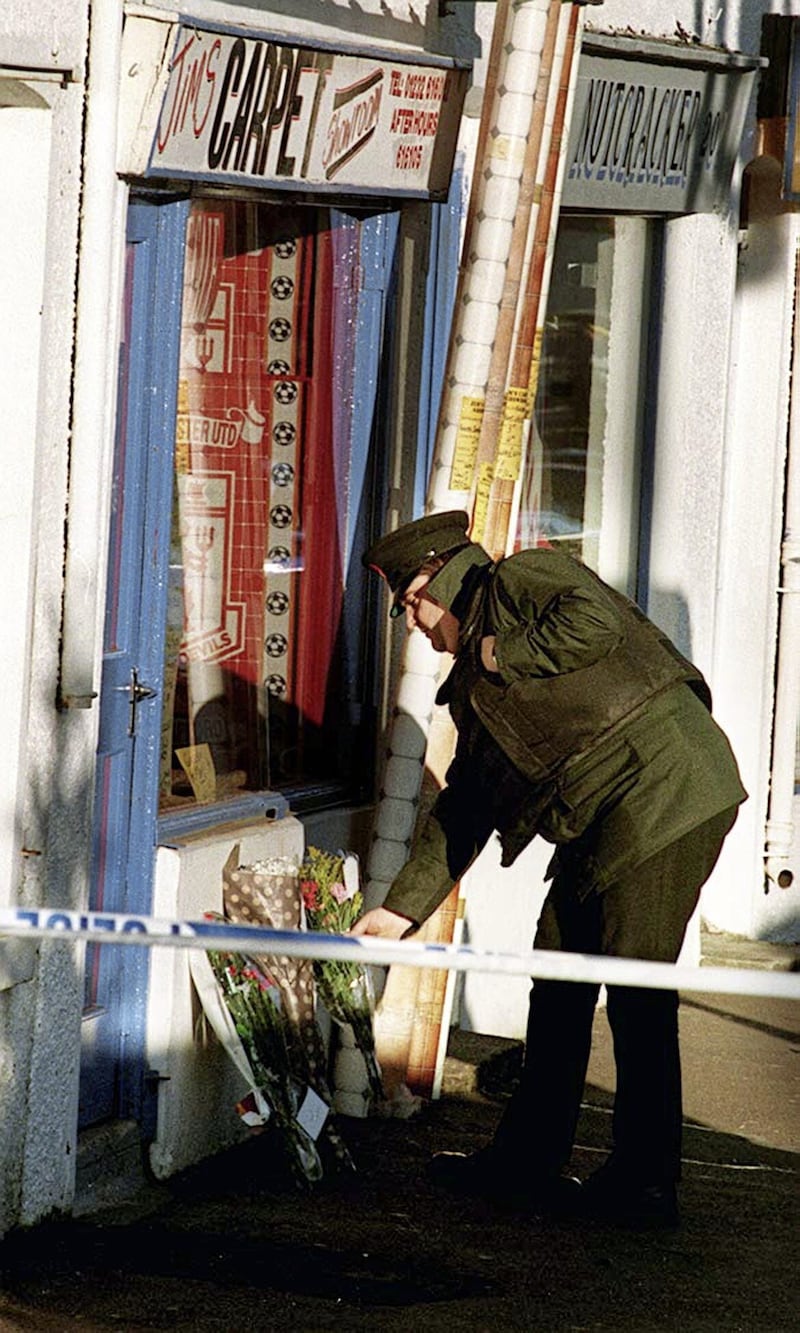 An RUC officer lays flowers on behalf of relatives of murdered loyalist Jim Guiney who was shot dead by the INLA in his carpet shopin Dunmurry this morning.PICTURE BY PAUL FAITH/PACEMAKER. 