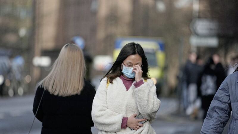 A woman wears a mask in Newcastle-upon-Tyne, near where two patients who tested positive for coronavirus are bring treated in the city&#39;s high consequence infectious disease unit 