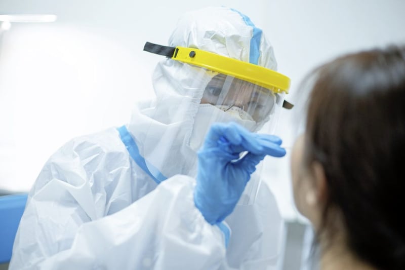 Coronavirus test - Medical worker taking a swab for corona virus sample from potentially infected woman with the isolation gown or protective suits and surgical face masks. 