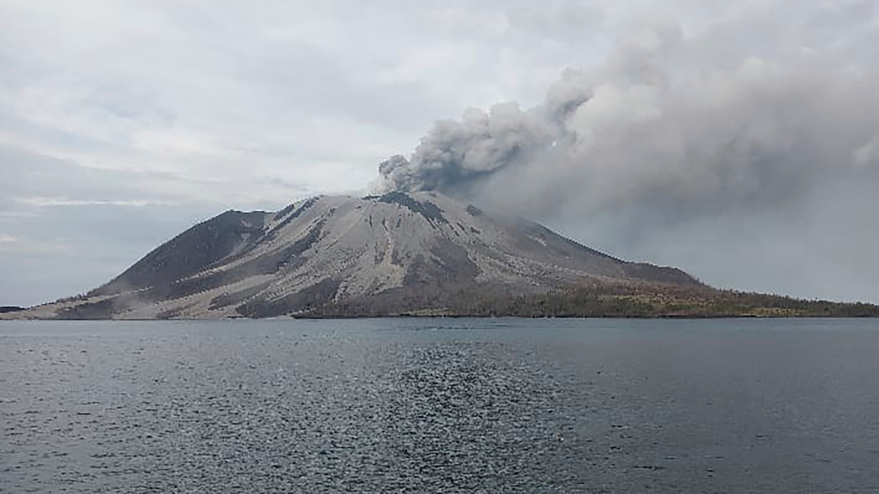 Indonesia’s Mount Ruang volcano spewed more hot clouds on Wednesday after an eruption the previous day forced the closure of schools and airports (Hendra Ambalao/AP)