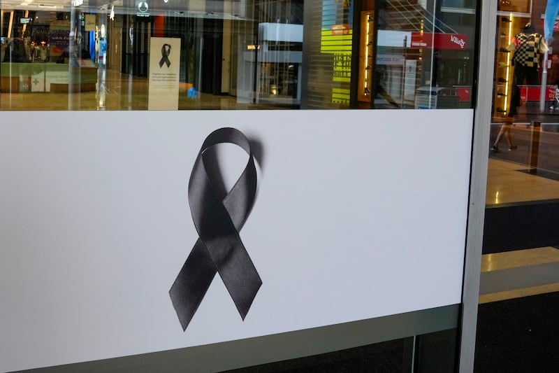 Black ribbons are displayed on the doors to the Westfield shopping centre (Mark Baker/AP)