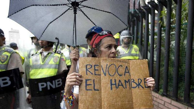 A woman holds a sign with a message that in reads in Spanish &quot;Revoke hunger&quot; during a protest march in Caracas, Venezuela in July 