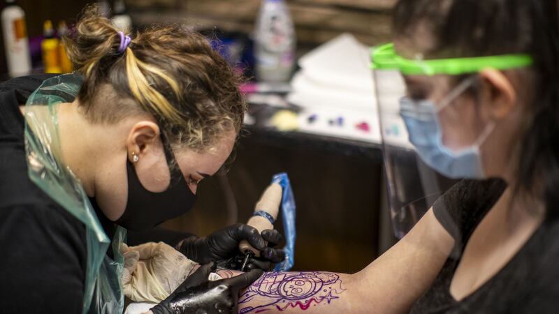 Tattoo artist Catherine Amos (left) tattooing customer Maria Speers at Belfast City Skinworks, as tattoo parlours in Northern Ireland are allowed to reopen as lockdown eases. Picture by Liam McBurney/PA Wire&nbsp;