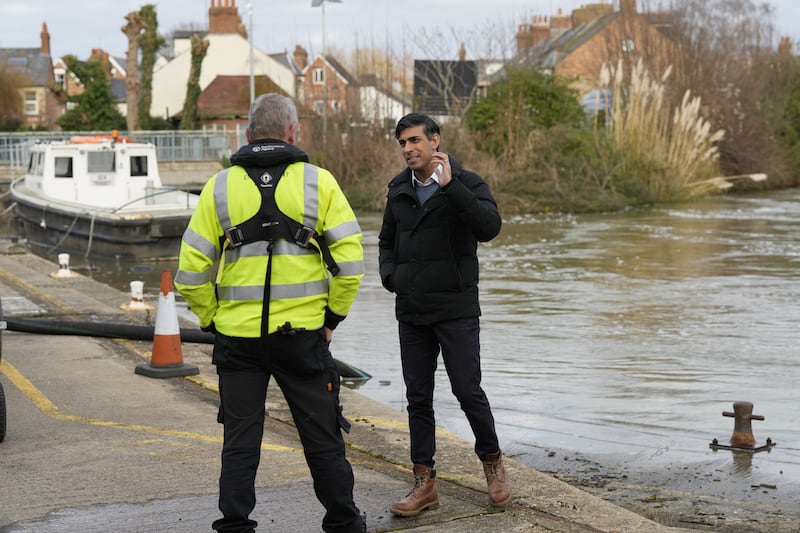 Prime Minister Rishi Sunak speaks to a member of the Environment Agency as he looks at flood defences during a visit to Osney, Oxford, Oxfordshire