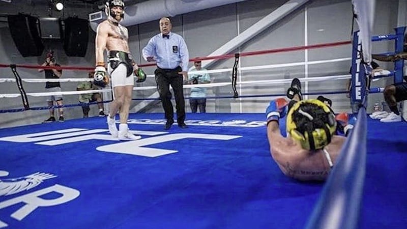 Paulie Malignaggi hits the deck as Conor McGregor stands over him  