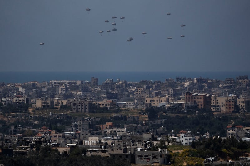 Parachutes drop supplies into the northern Gaza Strip, as seen from southern Israel (Leo Correa/AP)