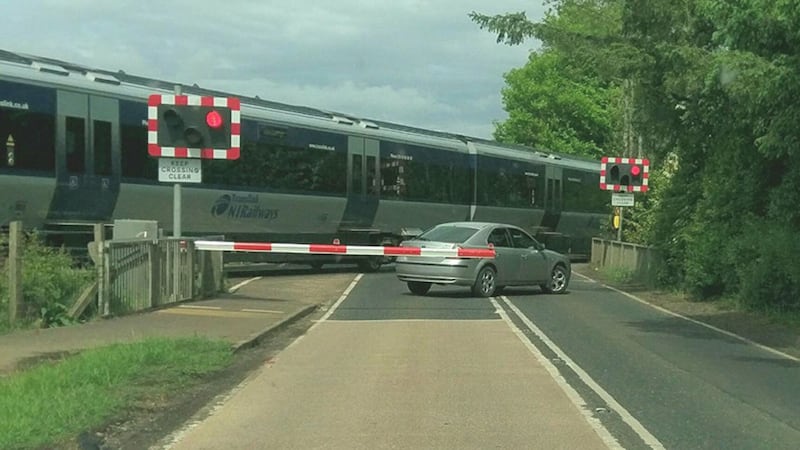 The car was pictured beyond the railway crossing barrier as the train sped past at Cullybackey, Co Antrim. Photo: Paul Hawkins&nbsp;