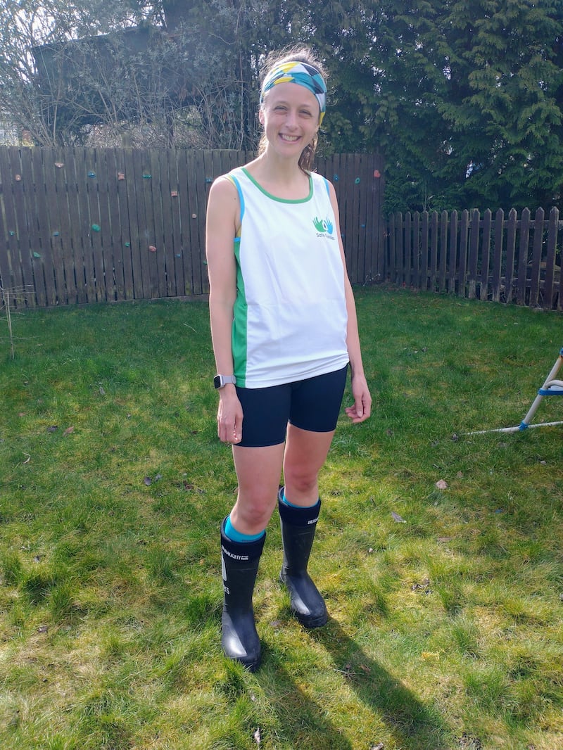 Woman standing with shorts, a tank top and trainers