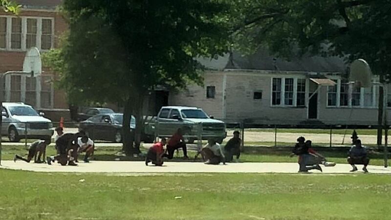 The 10 boys were playing basketball when they each took a knee.