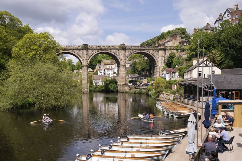 People enjoy the hot weather in rowing boats underneath the Knaresborough Viaduct on River Nidd in North Yorkshire