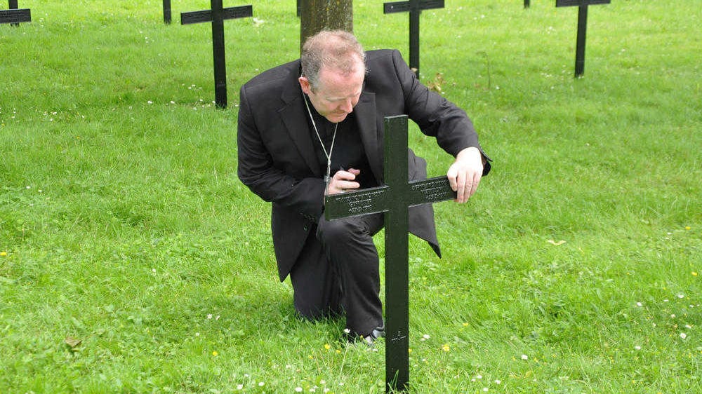Archbishop Eamon Martin in the graveyard of German soldiers