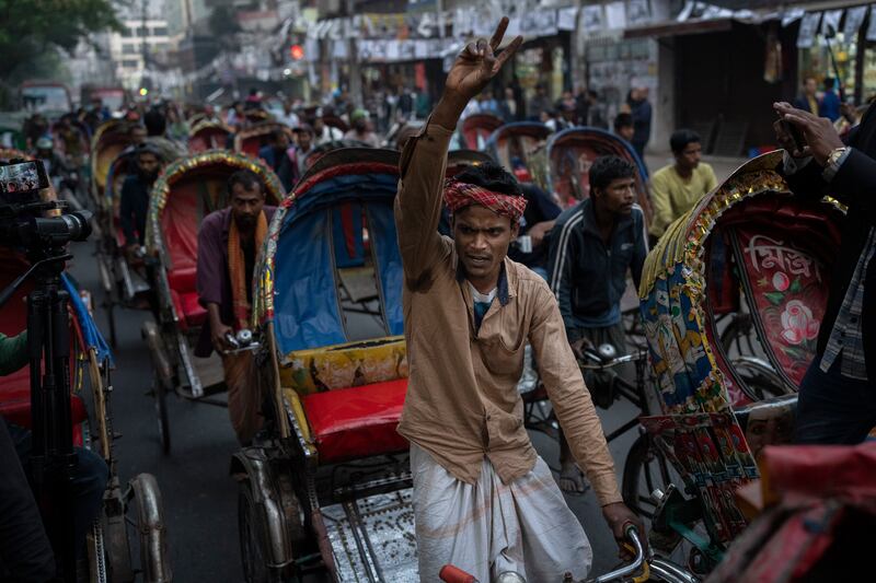 A rickshaw puller shouts slogans as supporters and activists of Gono Odhikar Porishod party march demanding free and fair elections and supporting the boycott of Sunday’s parliamentary elections, in Dhaka, Bangladesh (Altaf Qadri/AP)