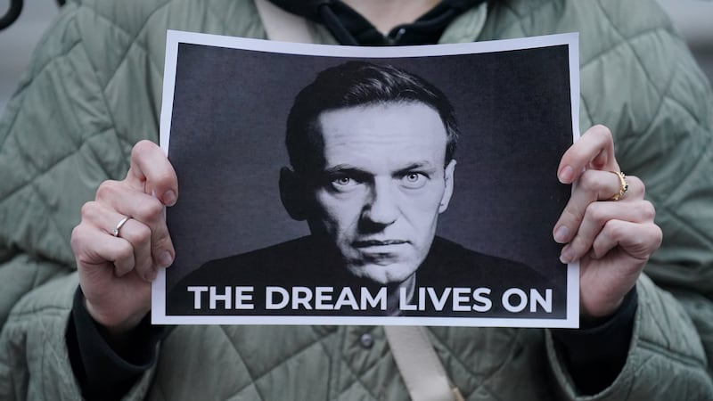 A protester holds a picture of Alexei Navalny in London