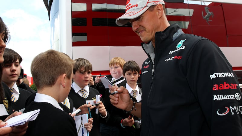 Michael Schumacher signs an autograph ahead of the British Grand Prix in 2012