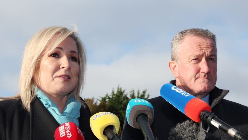 Sinn Fein's Michelle O'Neill and Conor Murphy stand in front of microphones, dressed in winter coats, in Hillsborough, Co Down
