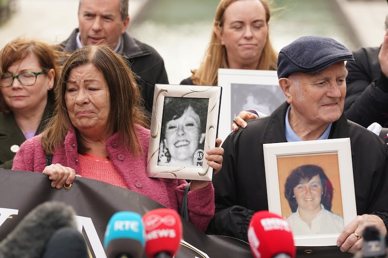 Survivors, family members and supporters hold photos of those they lost
