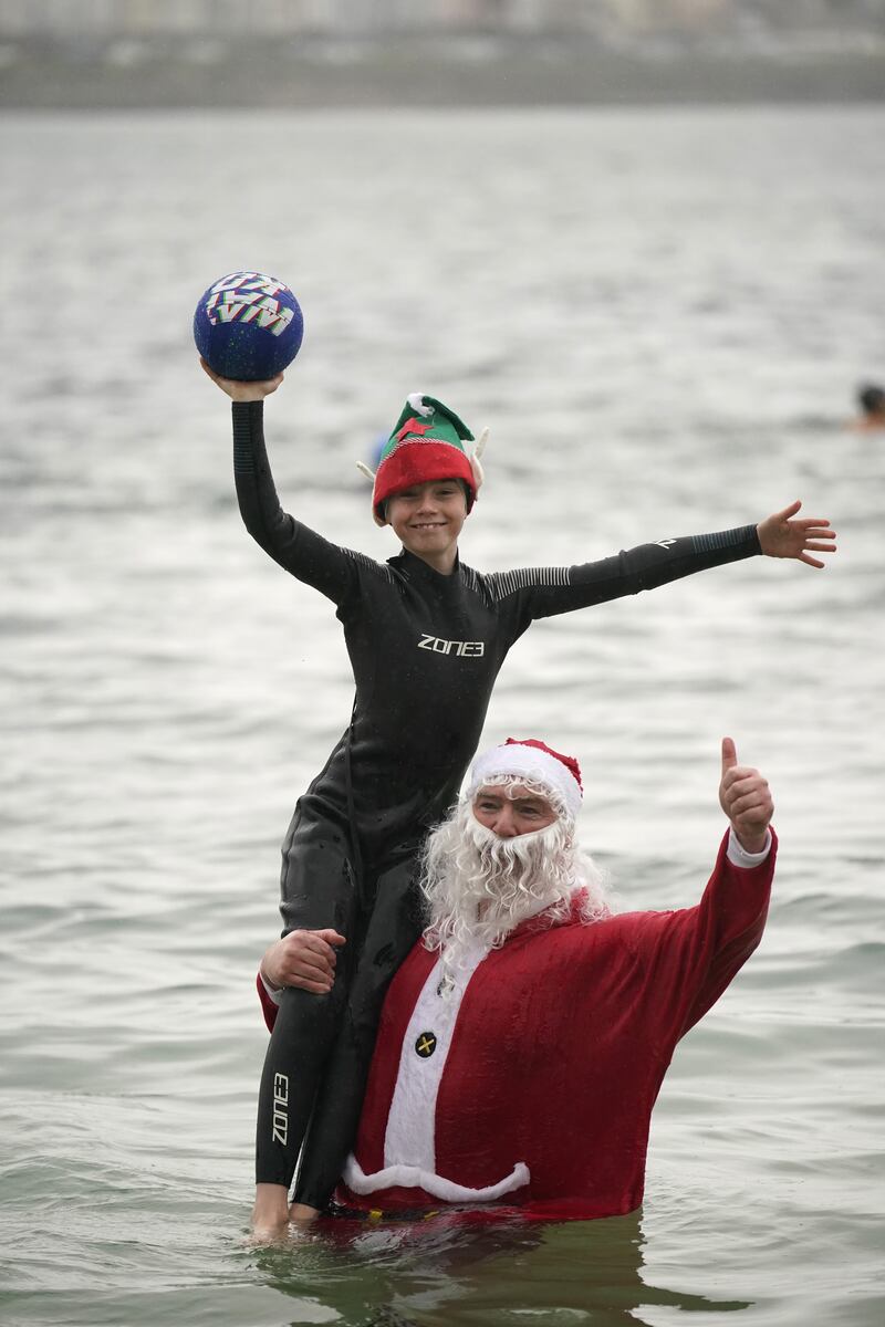 Patrick Corkery dressed as Santa and his son Matthew, 12, dressed as an elf, taking part in the annual Christmas Day swim.