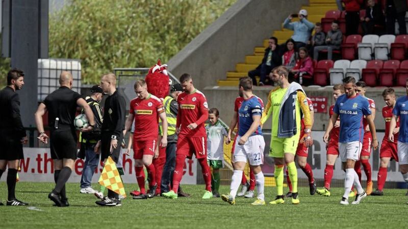 Cliftonville goalkeeper Roy Carroll (centre in yellow) walked past the Linfield line-up before the team's Danske Bank Premiership game at Solitude on Saturday. Photo by David Maginnis, Pacemaker Press.