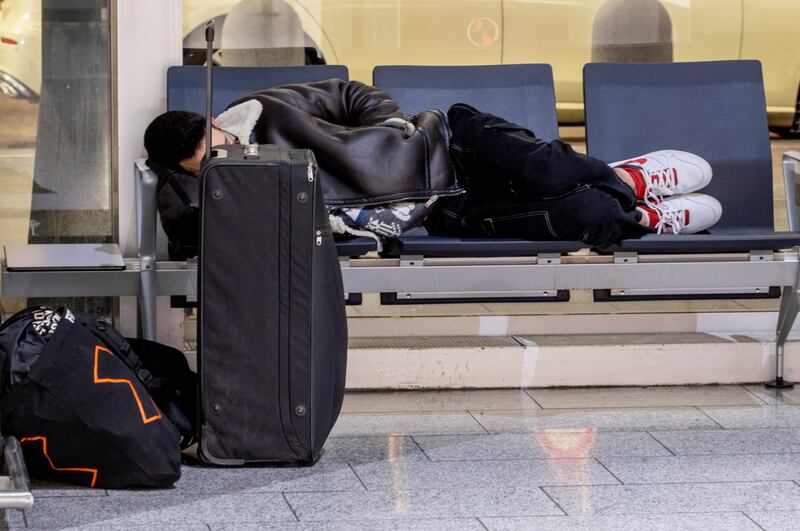 A man rests in a terminal at the airport in Frankfurt, Germany (Michael Probst/AP)