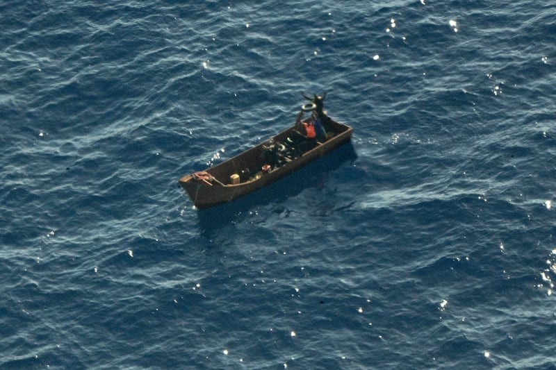 Overhead shot of four migrants in a small boat