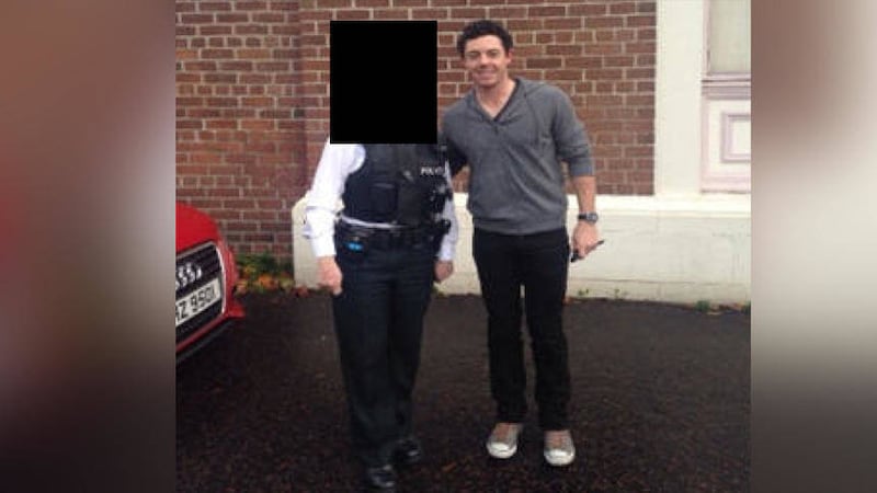A police officer posing for a photo with golfer Rory McIlroy 