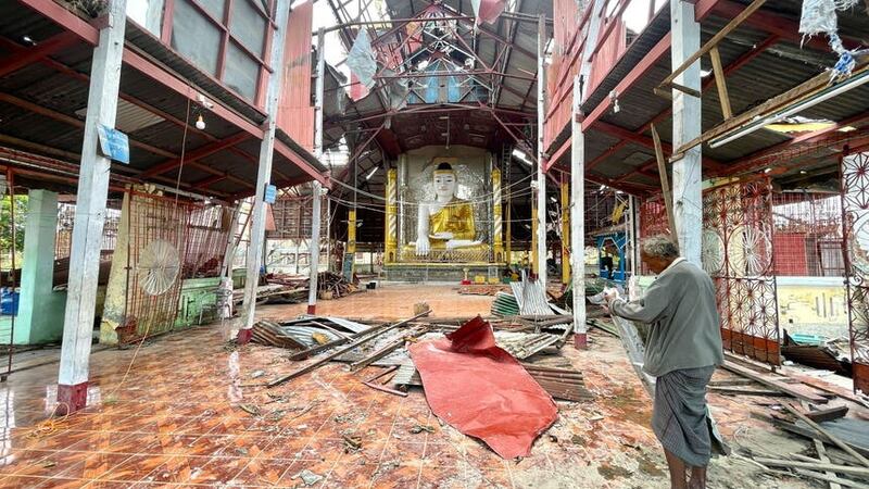 An ethnic Rakhine man stands inside a damaged pagoda to help repair the roof after Cyclone Mocha hit Sittwe township (AP)