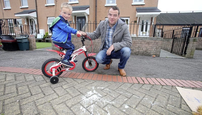 Damien Campbell with his son Cormac (3) beside one of paint bombs that were thrown into the Clandeboye area of Short Strand.Picture by Mal McCann 