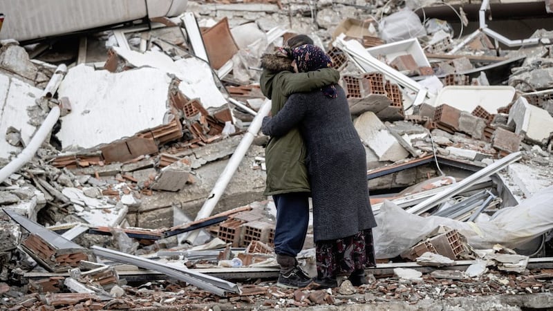 Women hug near a collapsed building in Turkey after one lost her brother in the devastating earthquake. Picture by Burak Kara/Getty Images 