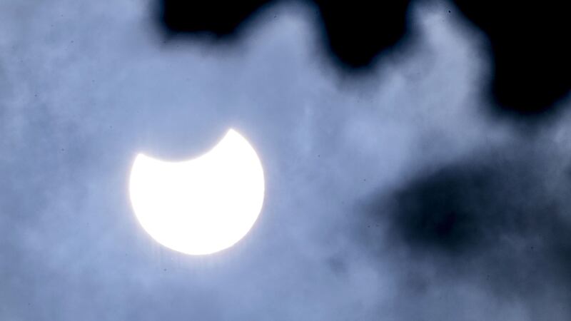 Despite cloudy skies, astronomy enthusiasts were able to see nearly a third of the sun being blocked out by the moon.