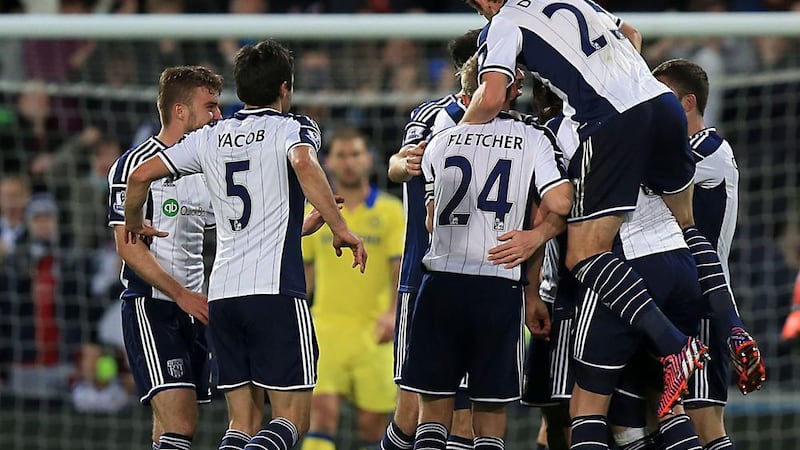West Bromwich Albion players mob Chris Brunt after his goal rounded off a 3-0 win over Chelsea at the Hawthorns Picture: PA 