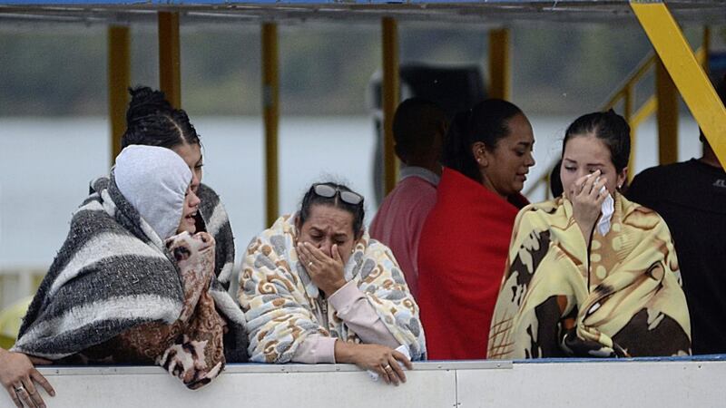 People wait for more information on tourists who were on a ferry that sank in a reservoir in Guatape, Colombia Picture: Luis Benavides/AP 