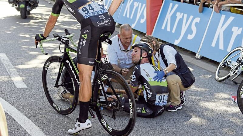 Britain&#39;s Mark Cavendish is treated by medics after he crashed during the sprint of the fourth stage of the Tour de France 
