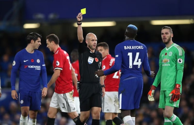Referee Anthony Taylor shows a yellow card to Chelsea's Tiemoue Bakayoko