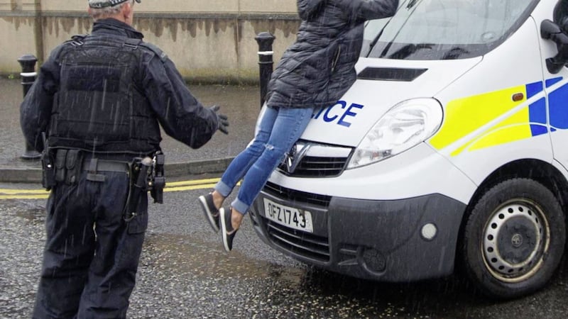 Amanda O&#39;Riordan, the mother of Brian Phelan&#39;s children, throws herself onto the police vehicle carrying Daniel Carroll outside Newry Magistrates Court. Picture by Newraypics.com 