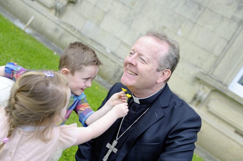 Does Archbishop Eamon Martin like butter? Cathal and Lucy Fegan with buttercups find out... Armagh will host a World Meeting of Families Festival on August 21. Picture by www.LiamMcArdle.com 