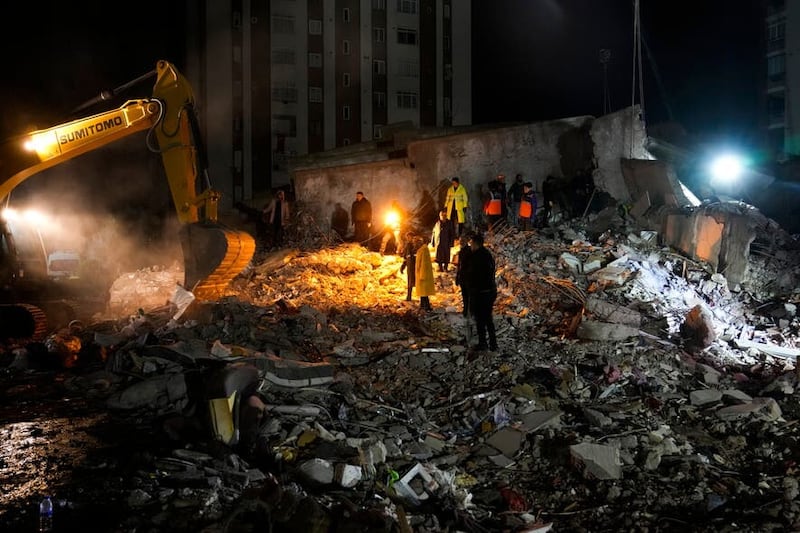 Emergency teams search through the rubble for people in a destroyed building in Adana, Turkey, Monday, Feb. 6, 2023. A powerful quake has knocked down multiple buildings in southeast Turkey and Syria and many casualties are feared. (AP Photo/Khalil Hamra)